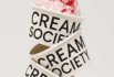 Stack of Cream Society ice cream cups with raspberry swirl ice cream.